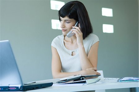 simsearch:633-01573622,k - Young businesswoman in office, using cell phone, looking away Foto de stock - Royalty Free Premium, Número: 695-03389344