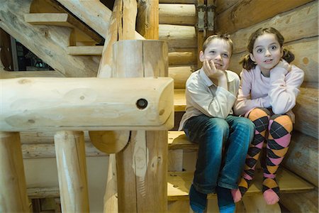 Boy and girl sitting side by side on steps, smiling, full length Stock Photo - Premium Royalty-Free, Code: 695-03389351