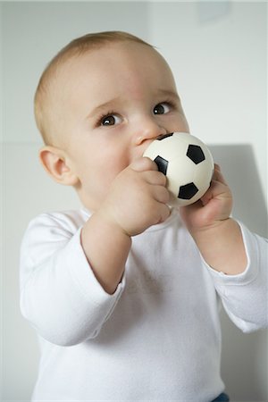 Baby biting ball, waist up Stock Photo - Premium Royalty-Free, Code: 695-03389384