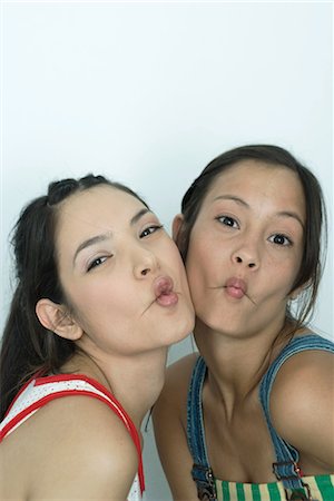 simsearch:400-03929864,k - Two young female friends puckering lips, looking at camera, portrait Stock Photo - Premium Royalty-Free, Code: 695-03389416