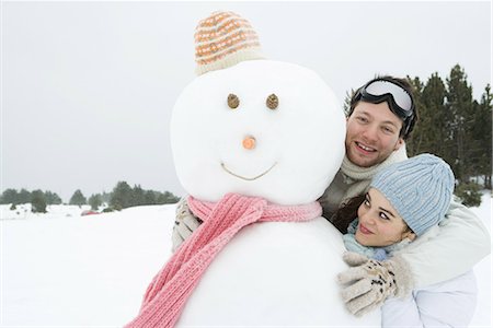 simsearch:695-03389446,k - Deux jeunes amis debout avec bonhomme de neige, les deux souriant, un appareil photo en regardant Photographie de stock - Premium Libres de Droits, Code: 695-03389448