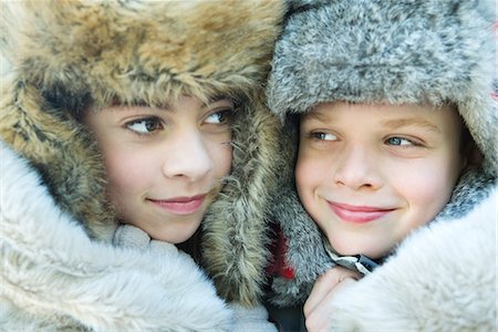 furry preteen - Sister and brother wearing fur caps, smiling, looking away, portrait Stock Photo - Premium Royalty-Free, Code: 695-03389458