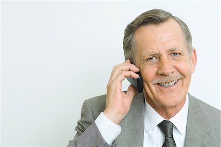 simsearch:693-06378950,k - Senior businessman using cell phone, smiling at camera, portrait Stock Photo - Premium Royalty-Free, Code: 695-03389460
