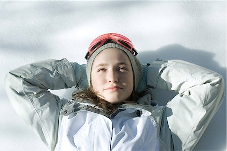 simsearch:633-01992734,k - Teen girl lying on snow with hands behind head, head and shoulders Foto de stock - Royalty Free Premium, Número: 695-03389534