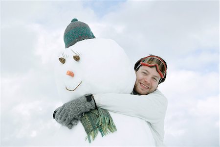 snow cone - Young man hugging snowman, low angle view Stock Photo - Premium Royalty-Free, Code: 695-03389545