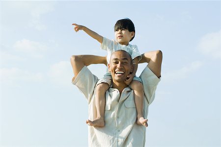 simsearch:632-01148477,k - Father carrying son on shoulders and smiling at camera, child pointing and looking away Stock Photo - Premium Royalty-Free, Code: 695-03389637