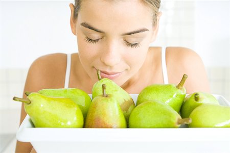 simsearch:695-03378760,k - Young woman with eyes closed, smelling a bowl of pears Foto de stock - Sin royalties Premium, Código: 695-03389812