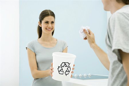 paper recycling studio photos - Man aiming paper ball toward recycling bin in woman's arms, cropped view Stock Photo - Premium Royalty-Free, Code: 695-03389874