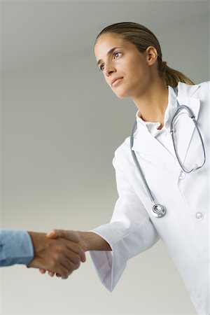 doctor patient shake hands - Female doctor shaking man's hand, low angle view, cropped Stock Photo - Premium Royalty-Free, Code: 695-03389913