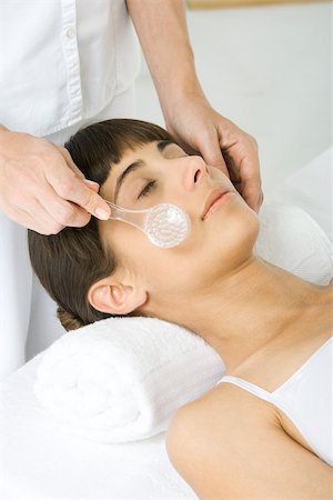 Woman having her face exfoliated, cropped view of woman using facial brush Stock Photo - Premium Royalty-Free, Code: 695-03389954