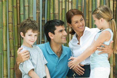 simsearch:695-03390229,k - Famille souriant à l'autre en face de bambou, portrait de groupe, garçon regardant la caméra Photographie de stock - Premium Libres de Droits, Code: 695-03389966
