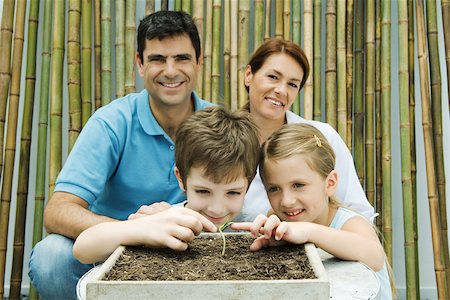 simsearch:614-06897590,k - Familie zusammen, Getopfte lächelnd in die Kamera Eltern, Kinder berühren Sämling Stockbilder - Premium RF Lizenzfrei, Bildnummer: 695-03389977