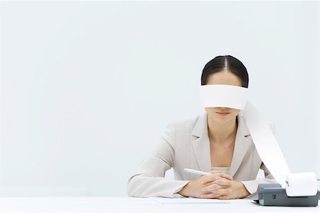 printout - Woman sitting at table with adding machine tape wrapped around her eyes Stock Photo - Premium Royalty-Free, Code: 695-03389999