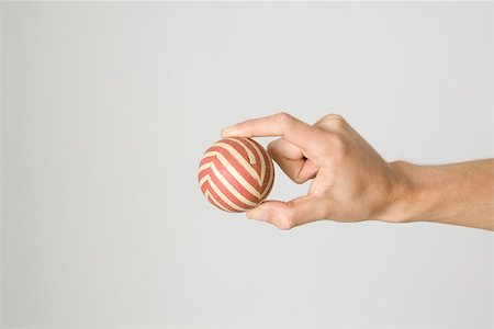 simsearch:696-03396016,k - Hand holding striped ball Stock Photo - Premium Royalty-Free, Code: 695-03380016