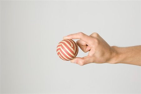 simsearch:6128-08798731,k - Hand holding striped ball Foto de stock - Sin royalties Premium, Código: 695-03380016