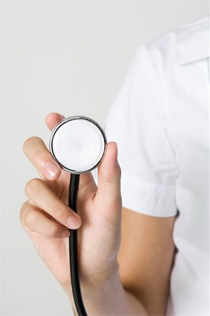 Nurse holding stethoscope, cropped view of hand Stock Photo - Premium Royalty-Free, Code: 695-03380011