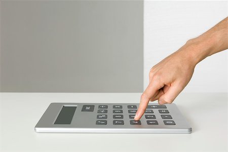 Hand using oversized calculator Stock Photo - Premium Royalty-Free, Code: 695-03380012