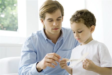 father and son with toy airplane - Father and son looking at toy airplane together Stock Photo - Premium Royalty-Free, Code: 695-03380036
