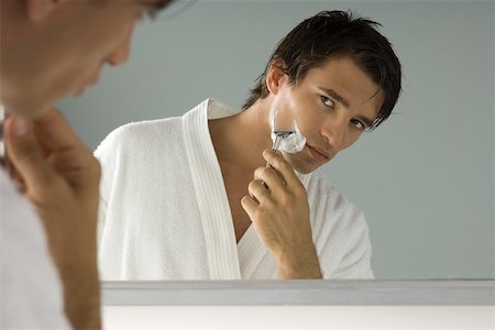 simsearch:696-03402708,k - Man looking at himself in mirror, shaving, wearing bathrobe Stock Photo - Premium Royalty-Free, Code: 695-03380067