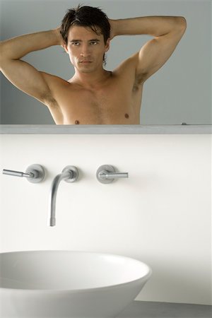 simsearch:696-03402708,k - Bare-chested man looking at self in bathroom mirror, hands behind head Stock Photo - Premium Royalty-Free, Code: 695-03380114