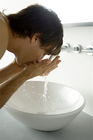 sanitario - Man bending over sink, splashing water on face, side view Foto de stock - Sin royalties Premium, Código: 695-03380118