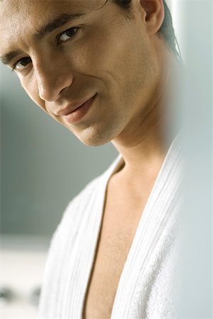 Man in bathrobe smiling seductively at camera, cropped Stock Photo - Premium Royalty-Free, Code: 695-03380125