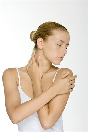 Woman with arms folded across chest, touching neck, eyes closed Stock Photo - Premium Royalty-Free, Code: 695-03380160