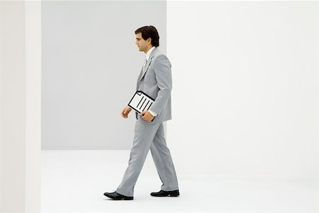 simplicity business - Businessman carrying document, side view Stock Photo - Premium Royalty-Free, Code: 695-03380185