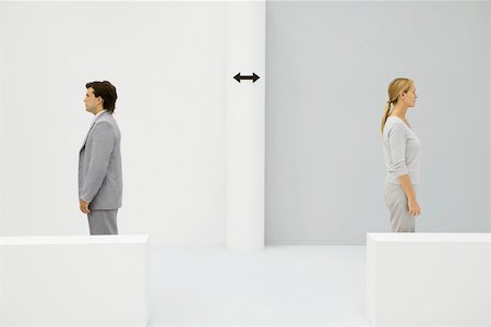 split - Male and female professionals standing apart, back to back, arrows between them Stock Photo - Premium Royalty-Free, Code: 695-03380194