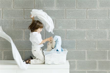 shoulder length hair - Little boy playing with laundry, smiling, side view Stock Photo - Premium Royalty-Free, Code: 695-03380208