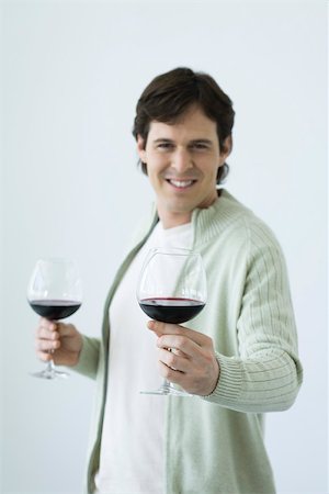 simsearch:695-03390286,k - Mann, der zwei Gläser Wein, hält sich eine Richtung Kamera Stockbilder - Premium RF Lizenzfrei, Bildnummer: 695-03380238