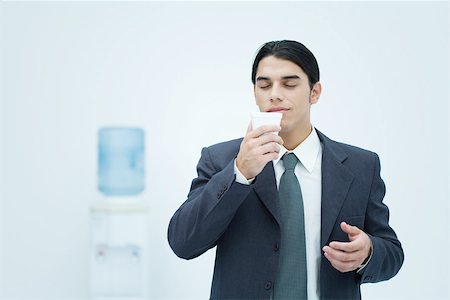 plastikbecher - Kaufmann holding und Pappbecher mit geschlossenen Augen, riechen Wasserkühler im Hintergrund Stockbilder - Premium RF Lizenzfrei, Bildnummer: 695-03380259