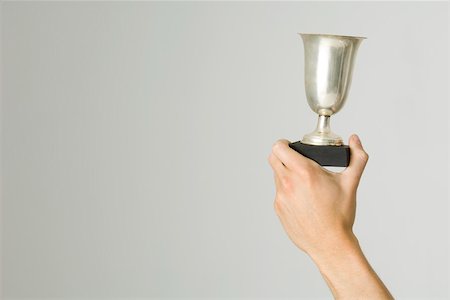 premio - Hand holding up trophy, cropped view Foto de stock - Sin royalties Premium, Código: 695-03380283