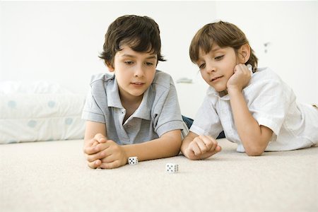 dice game picture - Two boys lying on the floor looking down at a pair of dice Stock Photo - Premium Royalty-Free, Code: 695-03380325