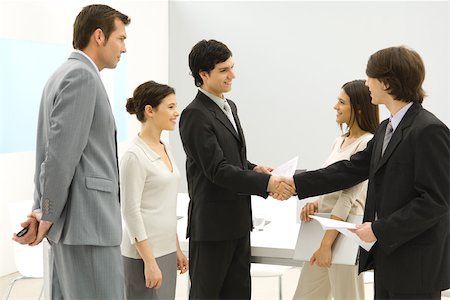 executive office profile - Business associates meeting, shaking hands while others watch Stock Photo - Premium Royalty-Free, Code: 695-03380376