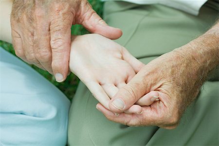Elderly person holding hand of young person, examining palm Stock Photo - Premium Royalty-Free, Code: 695-03380394