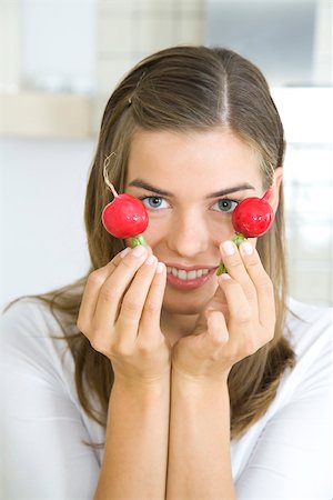 Woman holding up two radishes, smiling Stock Photo - Premium Royalty-Free, Code: 695-03380428