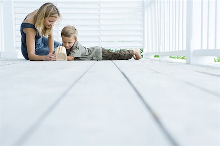 Mother and son sitting on floor of porch looking at birdhouse Stock Photo - Premium Royalty-Free, Code: 695-03380422