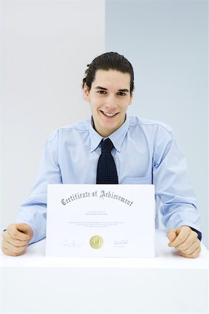 Young man receiving certificate of achievement Fotografie stock - Premium Royalty-Free, Codice: 695-03380461