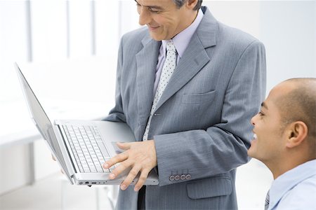 simsearch:695-05769165,k - Two businessmen looking at laptop computer together, both smiling Stock Photo - Premium Royalty-Free, Code: 695-03380518