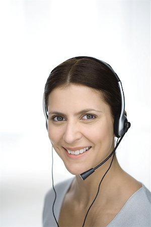 simsearch:695-03380008,k - Woman wearing headset, smiling at camera, portrait Fotografie stock - Premium Royalty-Free, Codice: 695-03380512