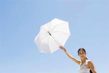 simsearch:632-05991689,k - Woman holding up parasol, smiling at camera Fotografie stock - Premium Royalty-Free, Codice: 695-03380595