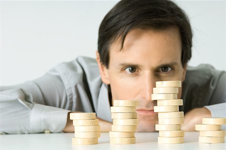 pic of person head down arms crossed - Man resting head on table, staring at stacked tokens Stock Photo - Premium Royalty-Free, Code: 695-03380591