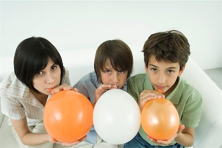 Mère et deux fils gonfler des ballons, en regardant la caméra, vue grand angle Photographie de stock - Premium Libres de Droits, Code: 695-03380676