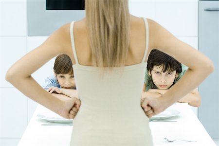 simsearch:614-08270203,k - Mother standing with hands on hips in front of two sulking boys, cropped view Fotografie stock - Premium Royalty-Free, Codice: 695-03380692