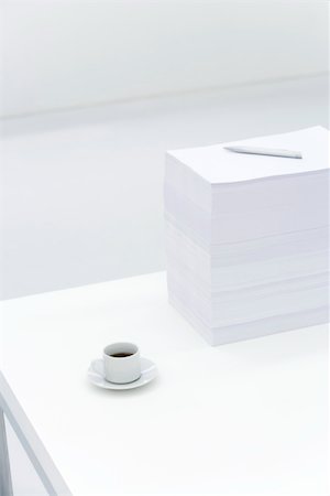 Coffee cup and large stack of documents on desk Foto de stock - Royalty Free Premium, Número: 695-03380714