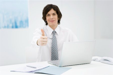 simsearch:632-03779793,k - Office worker sitting at desk, making thumbs up sign at camera Foto de stock - Royalty Free Premium, Número: 695-03380715