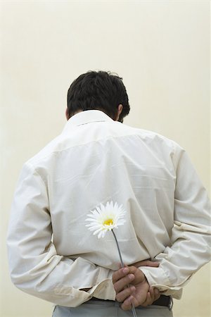 simsearch:600-06773113,k - Man holding flower behind his back, rear view Stock Photo - Premium Royalty-Free, Code: 695-03380712