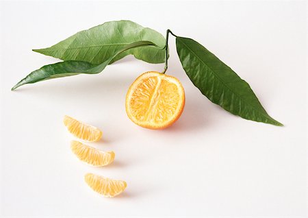 simsearch:695-03379760,k - Clementine half with leaves and segments Foto de stock - Sin royalties Premium, Código: 695-03380728