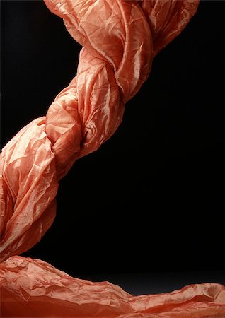 Twisted salmon-colored fabric against black background Stock Photo - Premium Royalty-Free, Code: 695-03380942